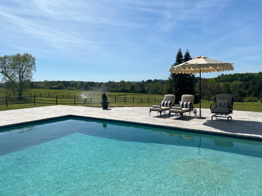 pool with a field and fencing in the background